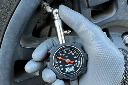 Digital tire gauge reading PSI on a valve stem
